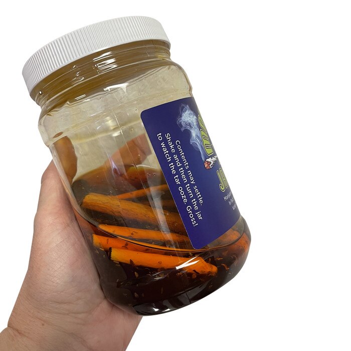 Marijuana Jar of Tar, health teaching tool, simulated marijuana tar held in hand with joint facsimiles, Health Edco, 78846