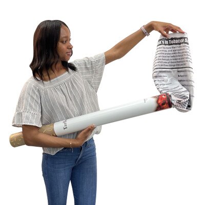 Young woman holding Health Edco's Giant Cigarette Model and pulling out educational banner about tobacco smoke dangers, 79110