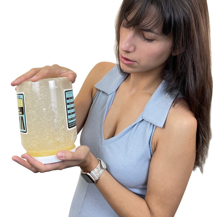 Young women watching oozing simulated fat in Vat of Fat, health education jar representing extra calories, Health Edco 79129
