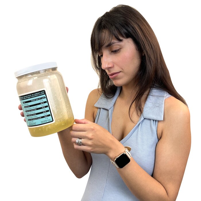 Young women reading label on Health Edco's Vat of Fat, a health education jar representing extra calories, Health Edco 79129