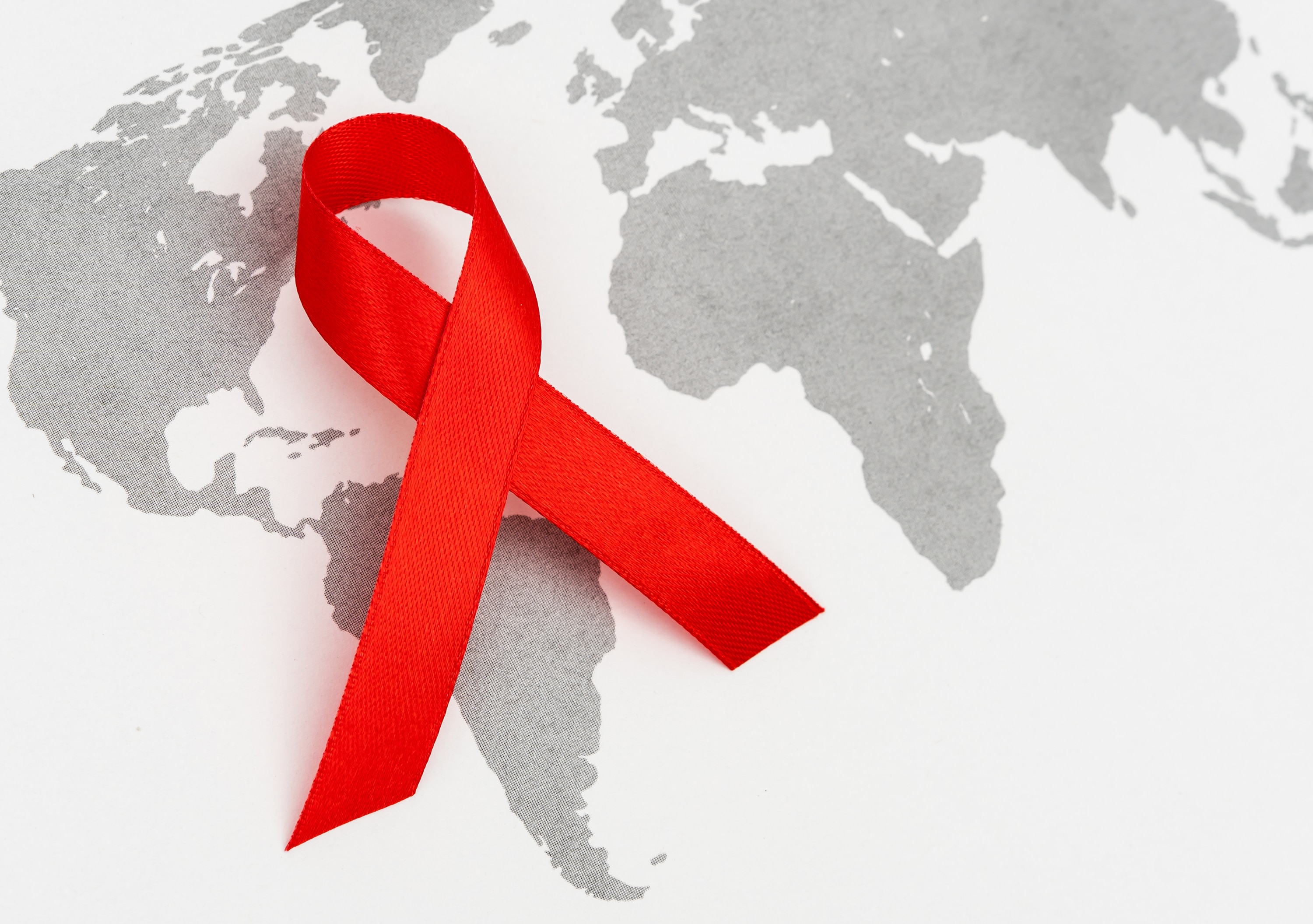 HIV/AIDS awareness ribbon superimposed on the continents for World AIDS Day