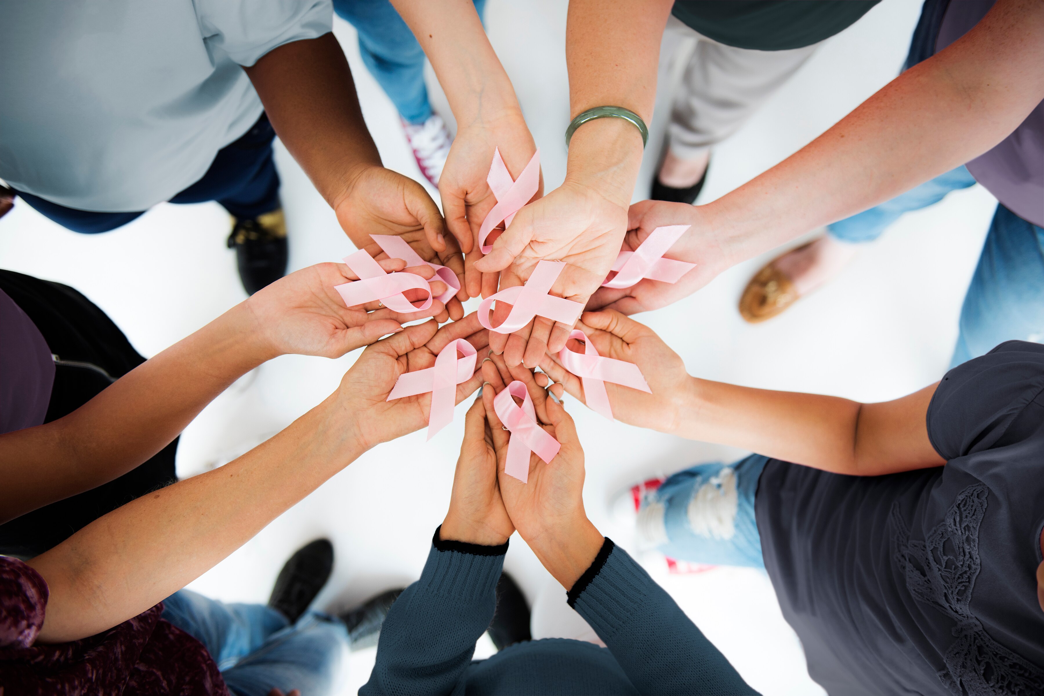 women’s hands holding breast cancer awareness ribbons