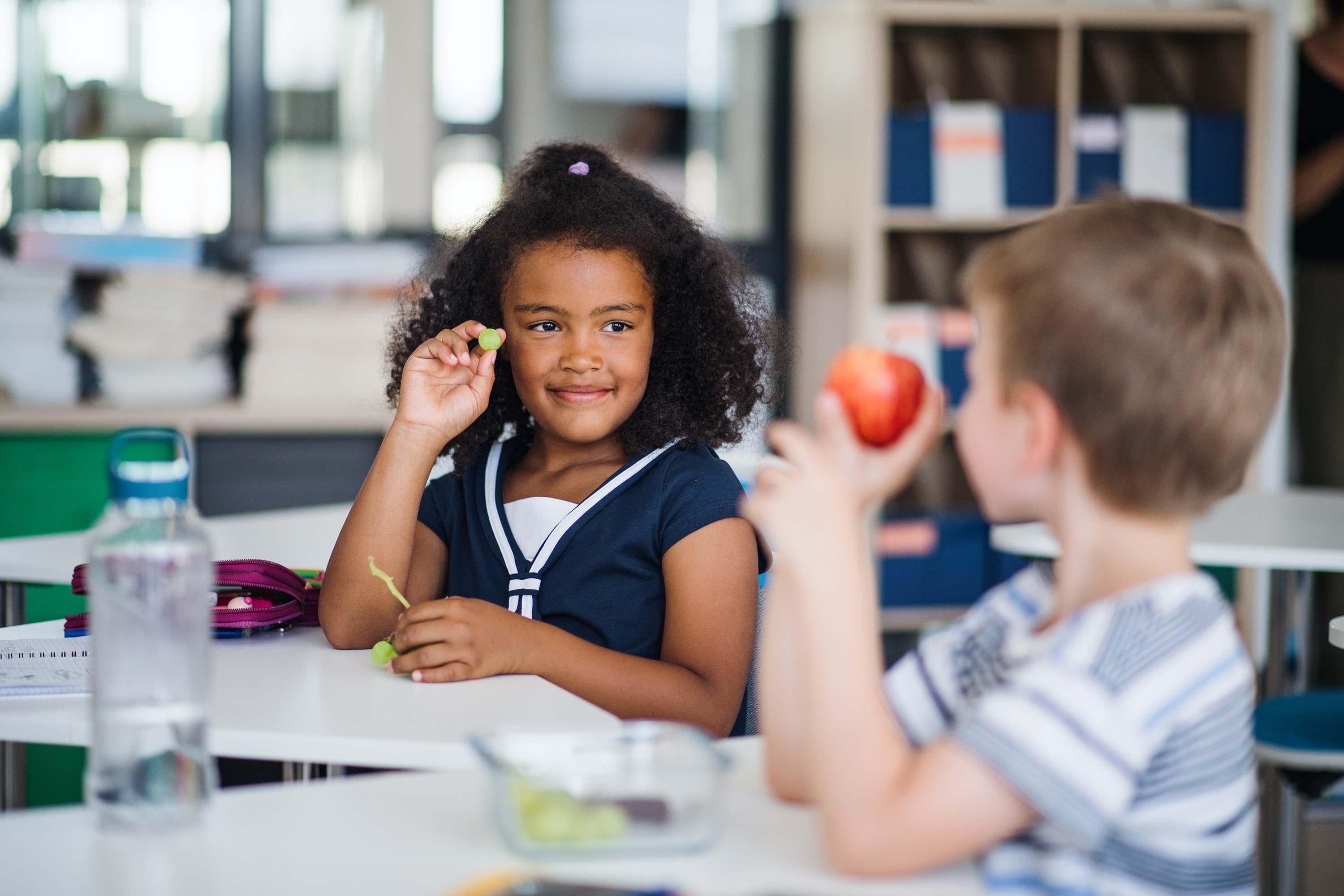 Children eating fruits as part of a healthy school lunch