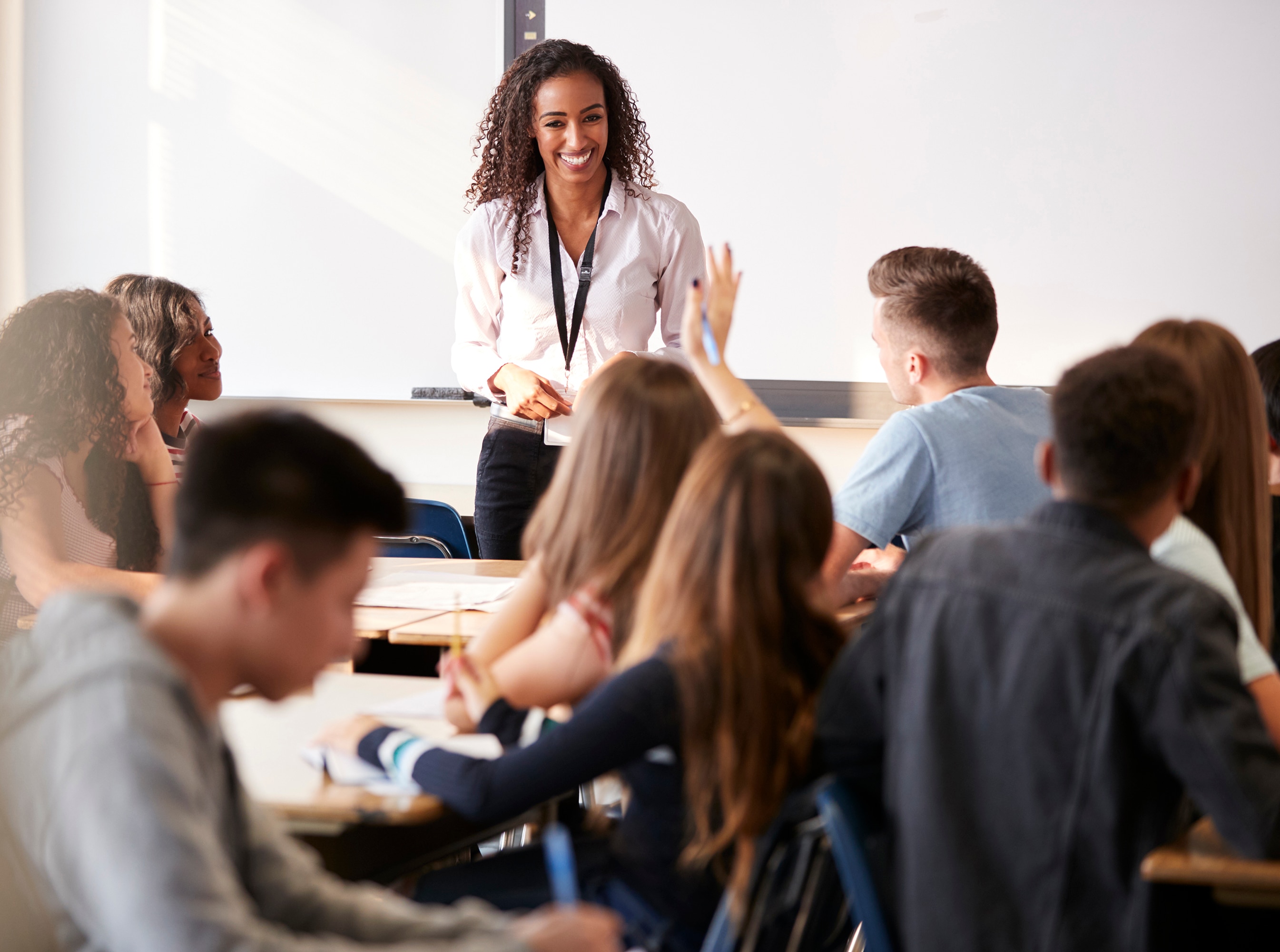 Happy young teacher instructing teens in a health education class