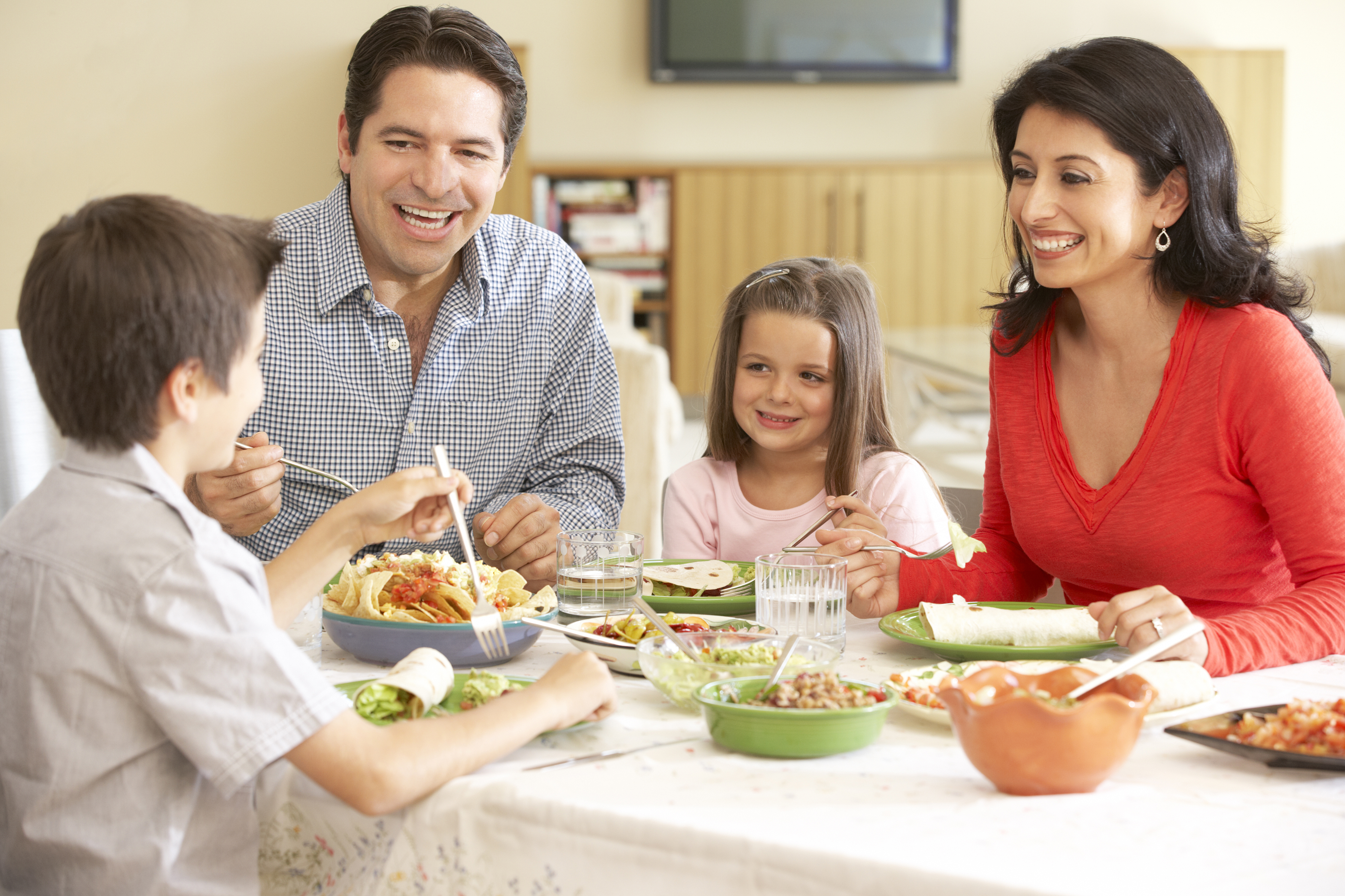 Young family with two parents and children enjoying a family meal